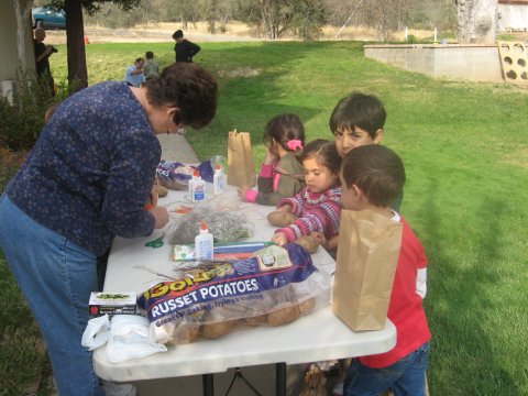 Marcia Taylor from St. George in Fresno, CA helping children make potato heads at the Harvest Festival